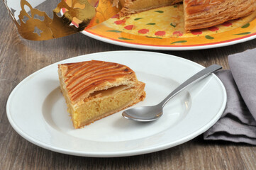Portion de Galette des rois à la frangipane servie dans une assiette avec une cuillère