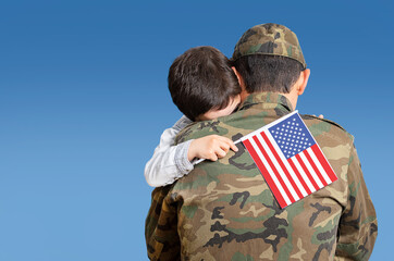 Shot of an adorable child hugging his father affectionately with the united states flag in his hand...