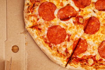 Closeup open box with pepperoni pizza. Top view.