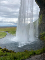 View from behind the falling Water of the Seljalandsfoss Waterfall in Iceland