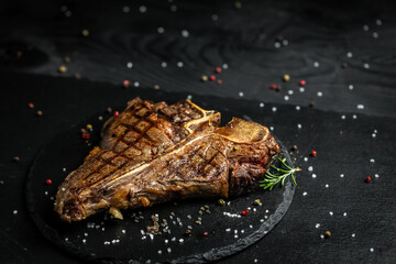 Dry Aged Barbecue Porterhouse Steak T-bone beef steak sliced with large fillet piece with herbs and...