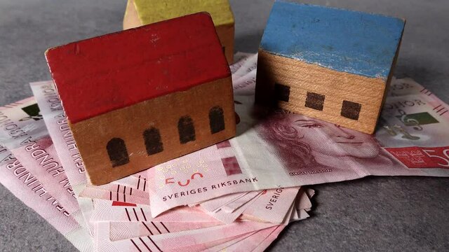 Stockholm, Sweden Toy houses on top of a pile of Swedish 500 kr notes.