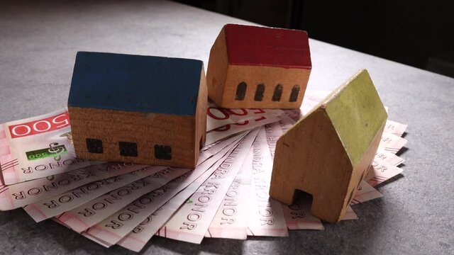 Stockholm, Sweden Toy houses on top of a pile of Swedish 500 kr notes.