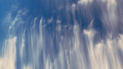 shot of patterned white clouds against a blue sky