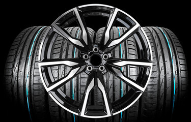 Car alloy wheel and tyre isolated on black background. New alloy wheel with tire for a car on a...
