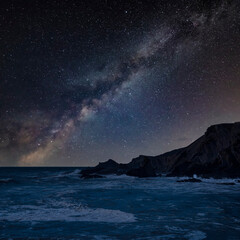 Digital composite image of Milky Way night sky over Stunning landscape image of view from Hartland Quay in Devon