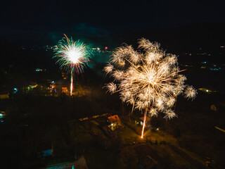 Aerial view of firework in the mountains at the end of winter season. New Years Eve fireworks fun. Colorful art. High quality photo