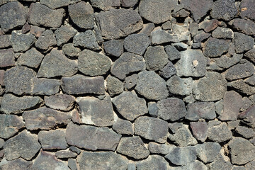 Texture of the black volcanic rock wall from Lanzarote, Canary Islands, Spain.