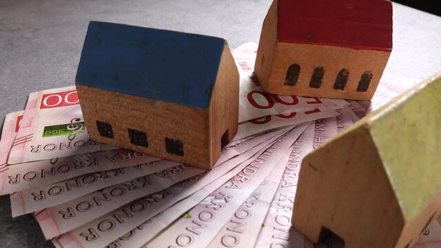 Stockholm, Sweden Toy houses on top of a pile of Swedish 500 kr notes.