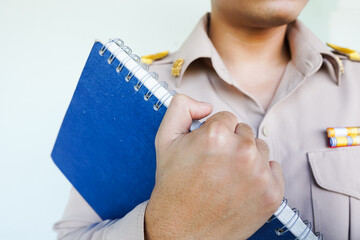 Male teacher wearing Thai civil servant uniform, holding a book, educational concept, Teacher's Day