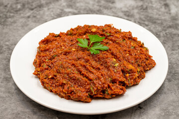 Chili paste on a dark background. spicy paste. A kind of adjika. Turkish cuisine appetizers. Horizontal view. Close up