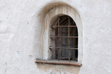 A small window with a lattice in the old tower.
