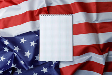 An empty notebook on the background of the American flag. Space for text. Close-up. Template for the design. Top view. Flat lay. The symbol of America