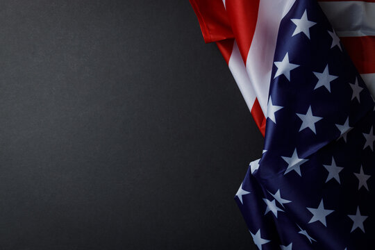 American flag on a black background with an empty space for writing text. The symbol of America. A template for a holiday. Textured black background. Close-up