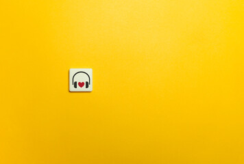 Headphones and Heart Symbol on Yellow Background. Favourite Song and Music Concept.