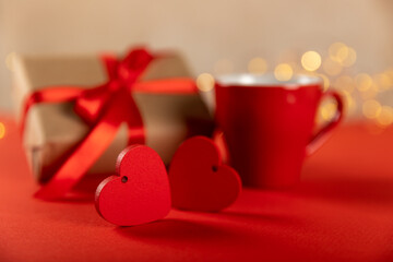 Gift box, red heart and red cup of tea on a red background. Valentine's Day gift. Holidays and love concept.