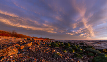 Baltic Sea rocks and beach sand at sunset