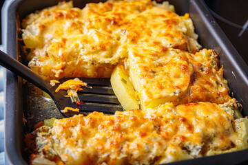 Zucchini casserole in a baking sheet. Cut the casserole into pieces.