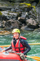 Fototapeta na wymiar Water sport portrait of smiling happy girl in river raft. Extreme sports and happiness concept.