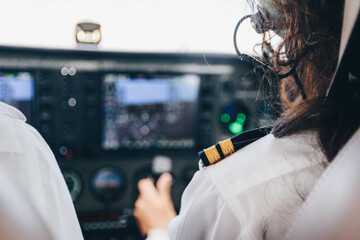 Inside view of the cockpit of an unrecognizable female student pilot flying her small plane holding the controls © Iván Berrocal
