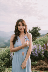 Fototapeta premium Portrait of thai young woman enjoying in blooming flower field