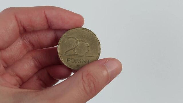 The hand examines the Hungarian 20 forint coin. Concept, money, business ideas.