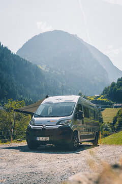 Camping car of rental company McRent in front of the mountains in Switzerland