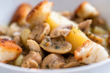 Primo piano di stufato di funghi e patate con crostini di pane 