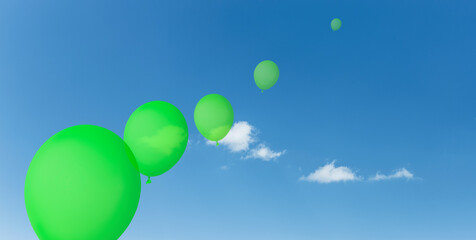 Grüne Luftballons vor Blauem Himmel mit weissen Wolken