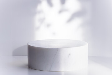 Marble cosmetic podium on light grey background with shadows. Cosmetic branding concept. Copy space for your design.