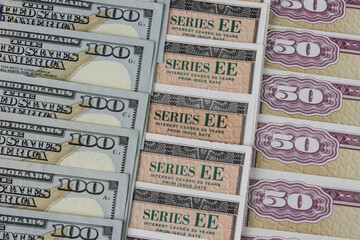US Savings Bonds and 100 Dollar bills, representing investment choices. Savings bonds are debt securities issued by the U.S. Department of the Treasury and issued in Series EE or Series I.