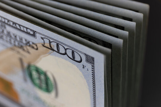 One Hundred Dollar bills stacked in a line - 100 Dollar bank notes in a stack. (Shallow depth of field)