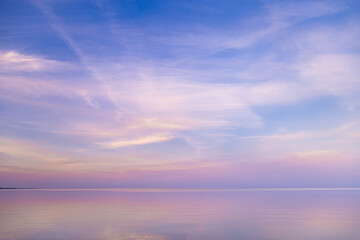 Beautiful sunset on sea, pastel colors and reflections on water, calm nature landscape with...