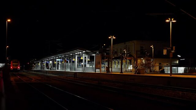 Einsamer beleuchteter Bahnhof bei Nacht, Bayern, Deutschland