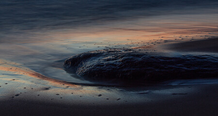 Fototapeta na wymiar Baltic Sea rocks and beach sand at sunset