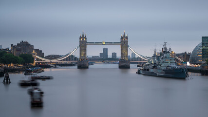 Fototapeta na wymiar Tower Bridge, spanning the river Thames, London, England. The day is cloudy and the water is smooth from a long exposure. 