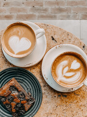 hot coffee latte art in white cup and chocolate brownie on white plate served in vintage wood tray on rustic wood table top view.