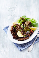 Fototapeta na wymiar Grilled pork steak with fresh salad. Bright wooden background.