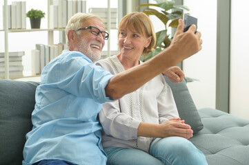 Caucasian happy seniors elderly are video calling to family or friends, relax at home, smiling healthy senior retired grandparents, older grandparent technology concept