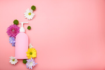 liquid soap with flowers on a pink background