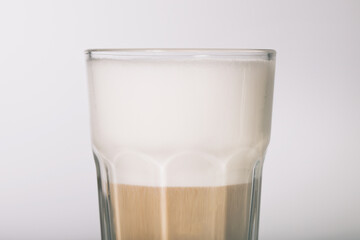 Preparing a caffe latte style hot drink from espresso and milk