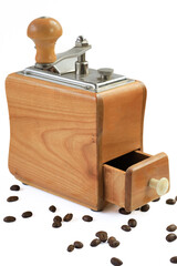 Old coffee grinder with beans around it on a white background with negative space top