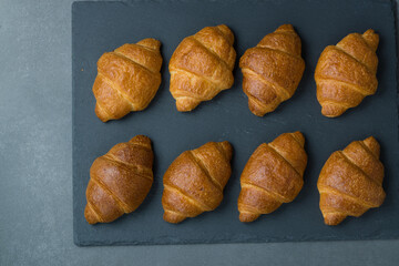 Group of croissant arranged in two rows and ready at the table for breakfast