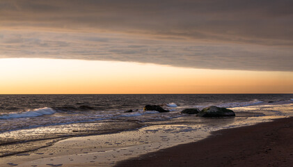 Baltic Sea rocks and beach sand at sunset