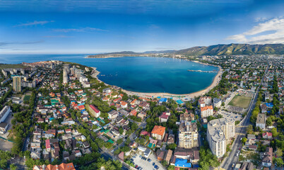Panorama of Gelendzhik resort from a height, the Black Sea. The Gelendzhik Bay, the Caucasus Mountains are visible. Along the bay there are resort beaches, sanatoriums and boarding houses - obrazy, fototapety, plakaty