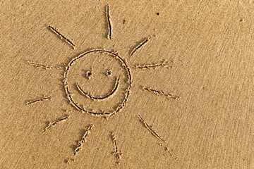 The sun with a smile drawn on the sand.
