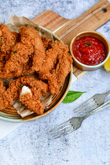 
 Crispy  deep fried   chicken strips and wedges potato. Breaded  with cornflakes chicken  breast fillets  with chilly peppers and fresh   basil on wooden rustic background