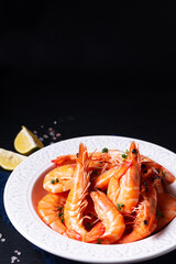 Food concept fresh boiled Shimps in ceramic plate on black slate stone board with copy space