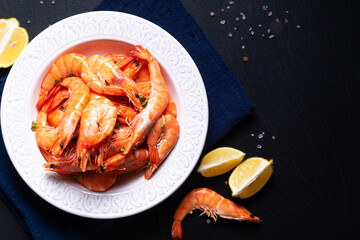 Food concept fresh boiled Shimps in ceramic plate on black slate stone board with copy space