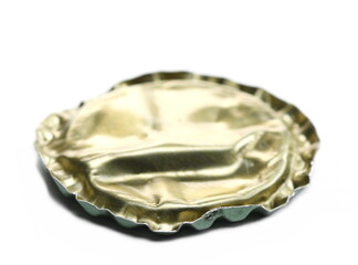 Golden flattened bottle cap for beer isolated on white, macro
